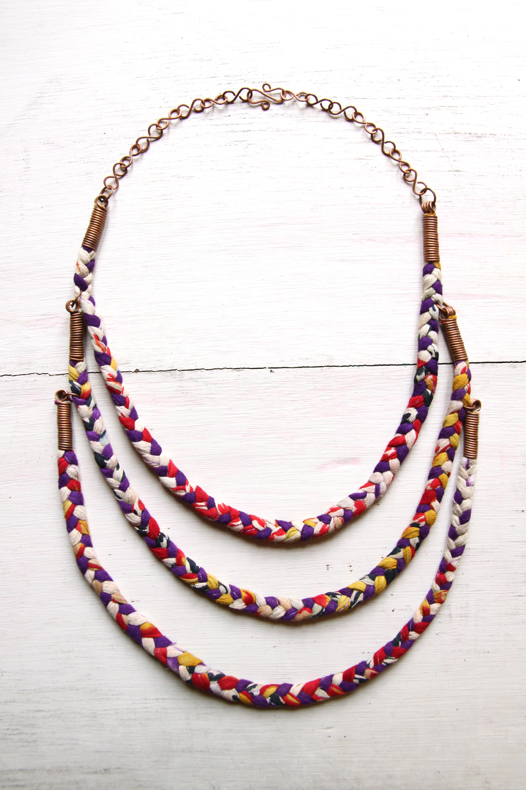 I think this is our most fun jewellery set! Vintage sari strips are woven together, meaning each necklace has its own unique combination of colours and patterning. This colourful piece features three braided strands with handmade hammered copper S-chain. Braided sari bracelet also available.